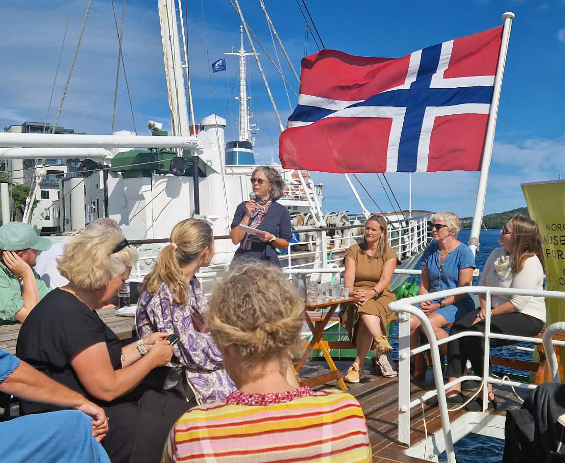 person snakker i mikrofon på båtdekk