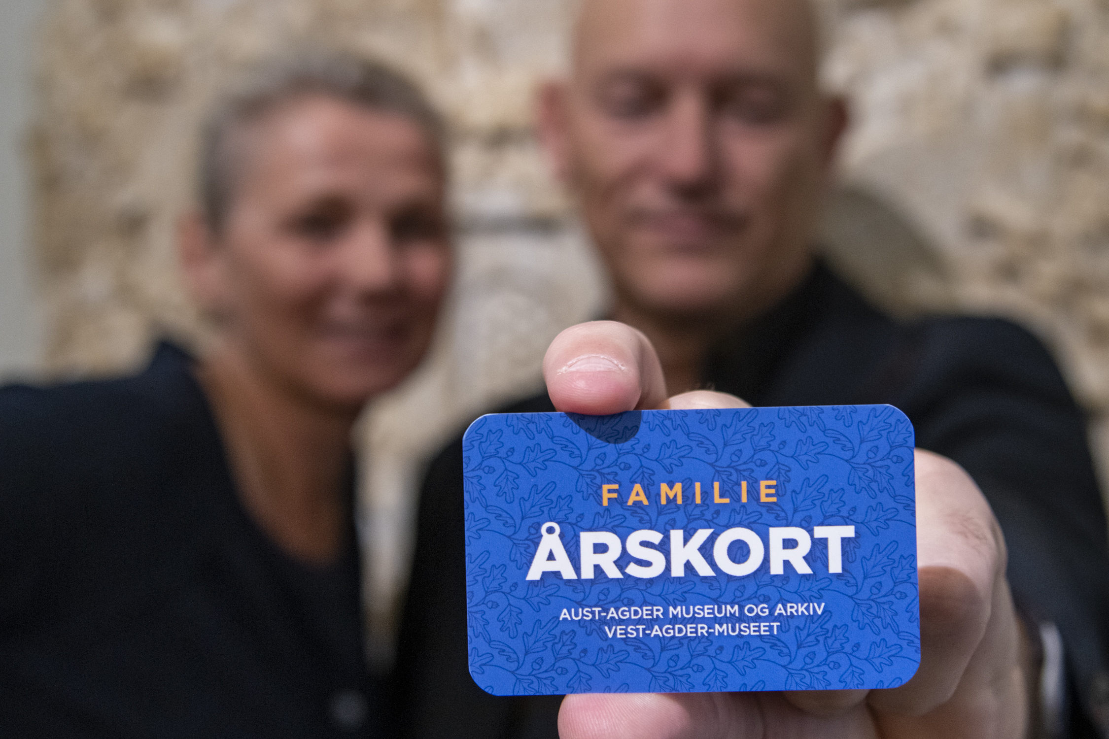 Personer holder frem blått kort med tekst årskort