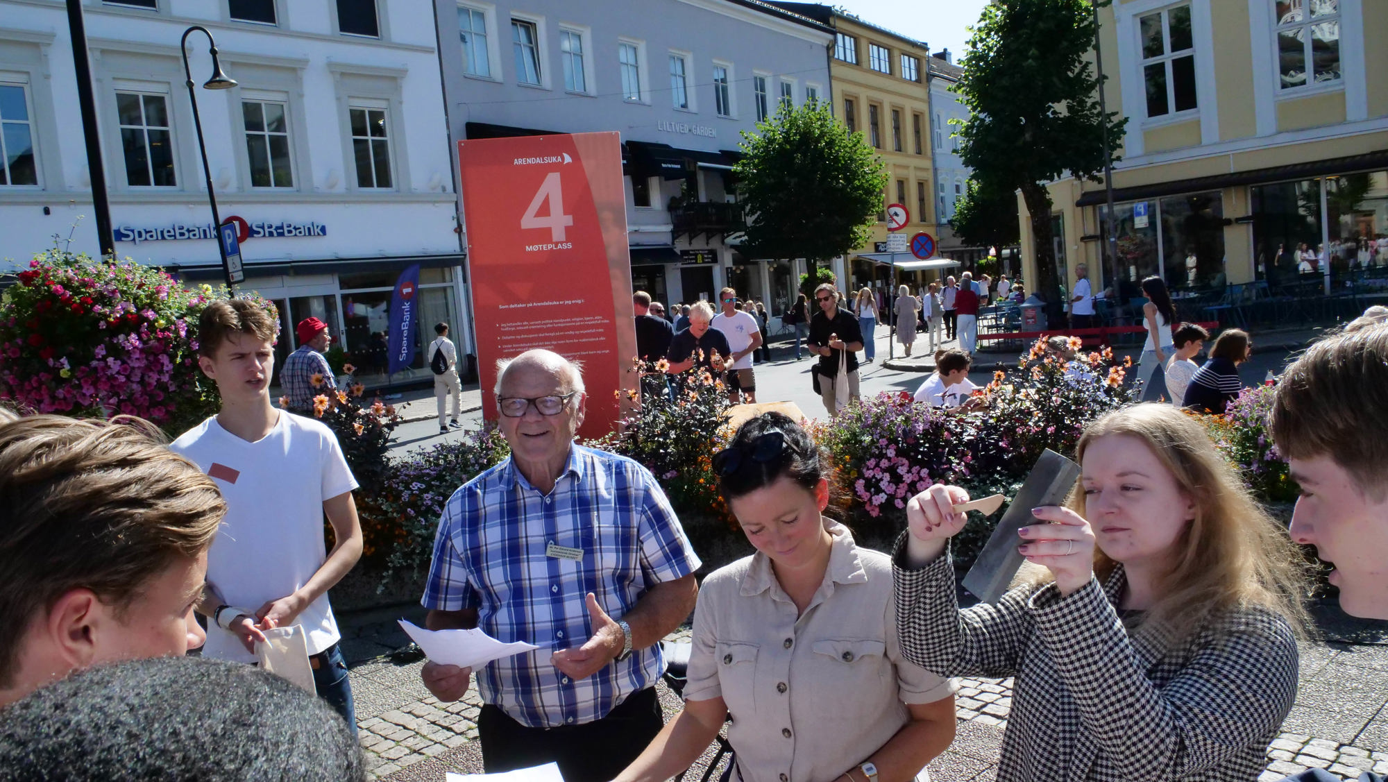 Person viser frem sort bit til tilskuere på torg i by