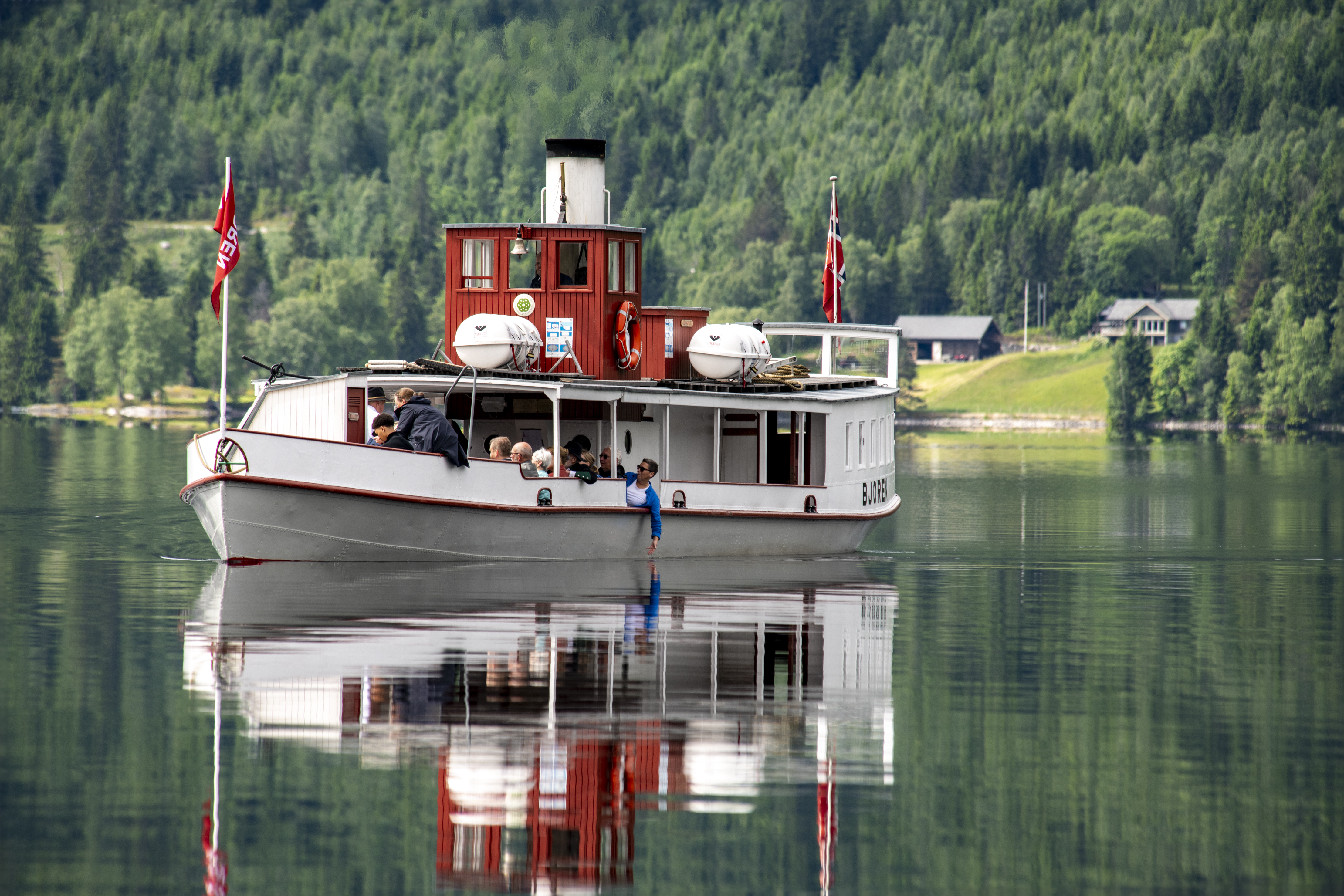 Dampbåt på blikkstille fjord