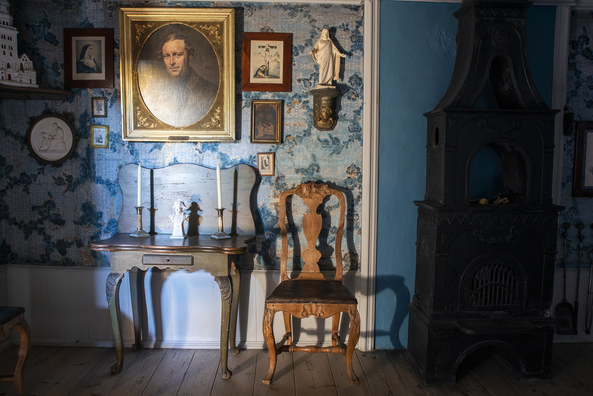 Interiørbilde med gammelt av gammel skipperhus med blå tapet og møbler.